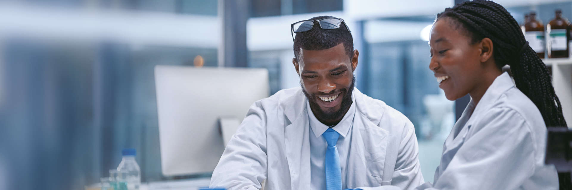 Enzymes for Molecular Biology, NGS, Black male and female scientists looking at mobile device in a laboratory setting